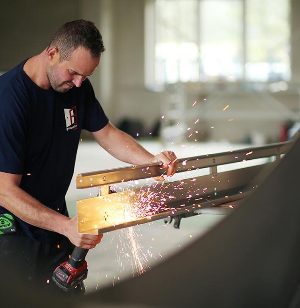 Ein Mitarbeiter schweißt den Rahmen eines Fensters